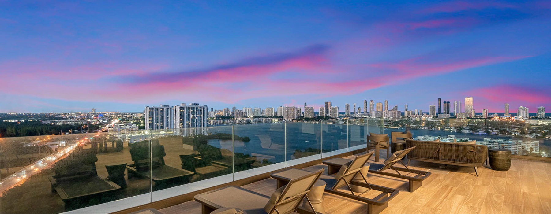 lounge chairs on rooftop deck with city and waterway views
